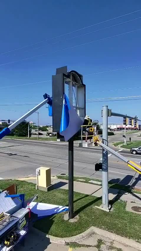 Crew at work installing a roadside pole sign